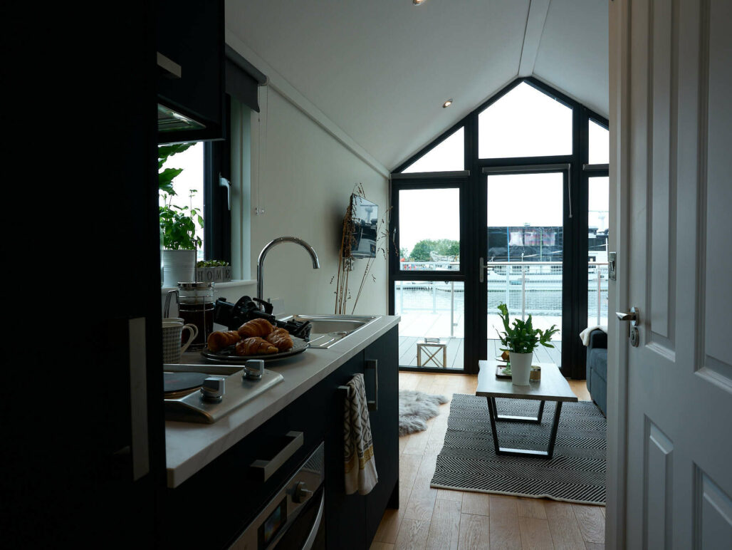 View of the interior of the C250 houseboat taken from the bedroom looking towards the open plan kitchen / living area