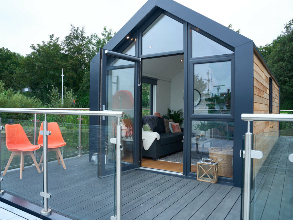 Front of a C250 houseboat showing a front balcony with 2 orange chairs on the decking