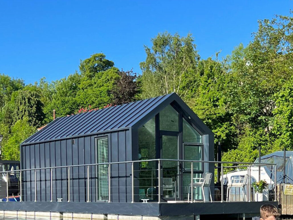 C250 houseboat with blue sky and trees in background