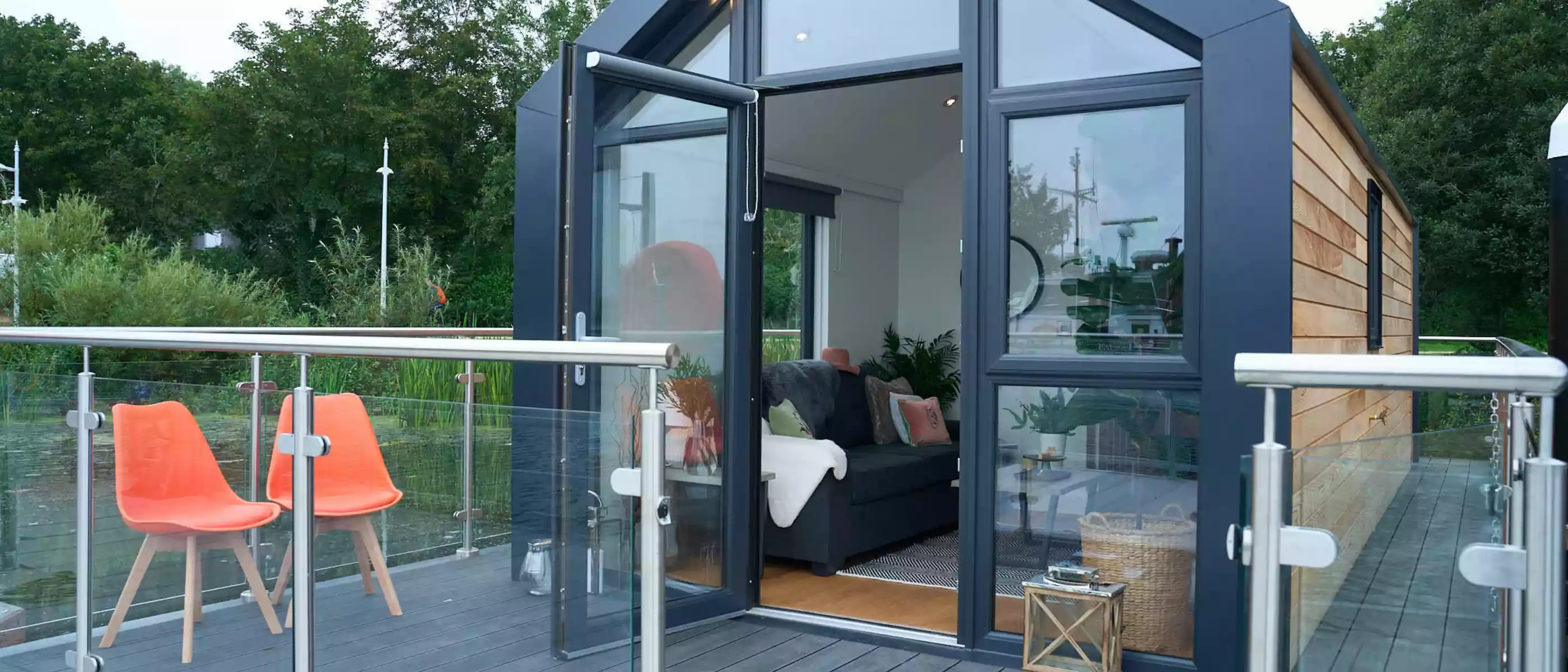 Front of a C250 houseboat showing a front balcony with 2 orange chairs on the decking